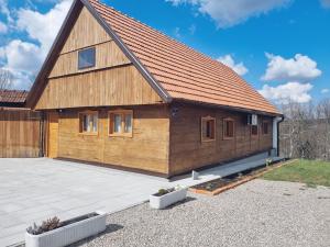 een groot houten huis met een grote patio bij Kablarovo Brdo in Krnjak