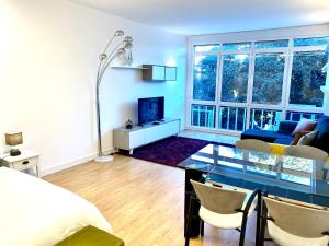 a bedroom with a bed and a table and a living room at Estoril 3 - Beach side Casino Garden Apartment in Estoril