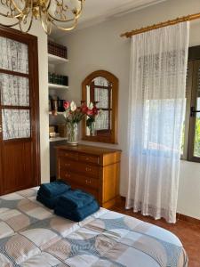 een slaapkamer met een bed, een dressoir en een spiegel bij Aura rural II in San Pablo de los Montes