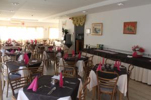 een restaurant met tafels en stoelen met roze servetten erop bij Hotel Galileo in Rimini