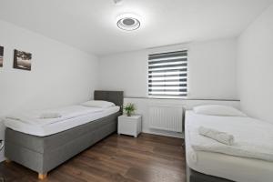 1 dormitorio con 2 camas y ventana en ADN Suites - NETFLIX - modern and smart, en Günzburg