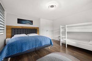 Schlafzimmer mit einem blauen Bett und Etagenbetten in der Unterkunft ADN Suites - NETFLIX - modern and smart in Günzburg