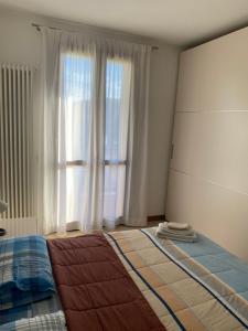 a bedroom with a bed and a large window at Dante Zara in Borgata Zarattini
