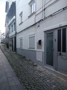 una calle adoquinada junto a un edificio blanco en Casa Amado Fundão en Fundão