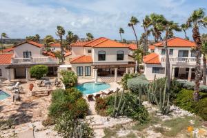 an aerial view of a house with a swimming pool and palm trees at Luxurious Ocean View Tierra del Sol Villa in Palm-Eagle Beach