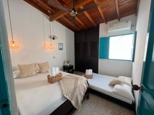 1 dormitorio con 2 camas y ventana en Cabaña La Aldea - Santorini Colombiano en Doradal