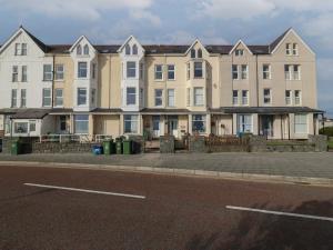 a row of buildings on the side of a street at Tonnau Waves in Pwllheli