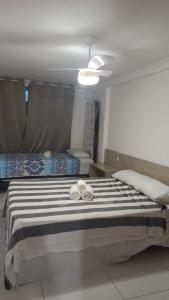 a bedroom with a large bed with two towels on it at ISRAEL FLAT DUPLEX C/ PISCINA in João Pessoa