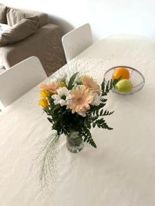 a vase of flowers on a white table at Spacious 2 rooms apartment in Helsinki Design District, own balcony in Helsinki