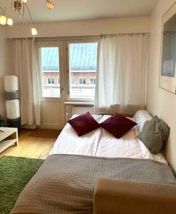 Un dormitorio con una cama grande con almohadas. en Spacious 2 rooms apartment in Helsinki Design District, own balcony, en Helsinki