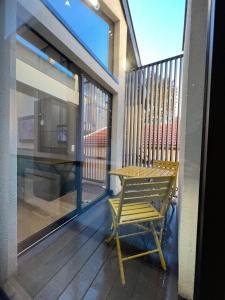南錫的住宿－Les suites de Stanislas jacuzzi & spa，一张木椅,位于带桌子的阳台