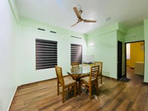 a dining room with a table and chairs and a ceiling fan at AL-Kabeer Lavender budget rooms in Trivandrum
