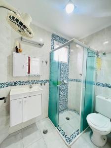 een badkamer met een glazen douche en een toilet bij Ilhas do Mel/Praia Grande Caiçara São Paulo in Praia Grande
