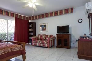 sala de estar con sofá y TV en Aruba Palm Beach Villa, en Palm-Eagle Beach