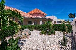 una casa con un jardín delante de ella en Aruba Palm Beach Villa, en Palm-Eagle Beach