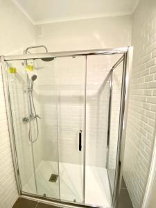um chuveiro com uma porta de vidro na casa de banho em Estoril Beach Side Casino Garden Apartment Cascais em Estoril