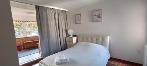 a bedroom with a white bed and a window at Reis Magos Beach Caniço Sea line Apartment in Caniço