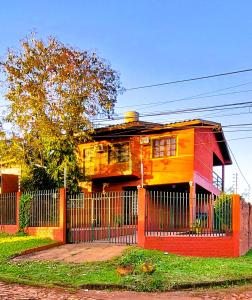 een kleurrijk huis met een hek ervoor bij Casa Yvy Pytã in Puerto Iguazú