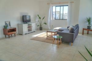 uma sala de estar com um sofá e uma televisão em Double bedroom with ensuite in spacious corner apartment em Birkirkara
