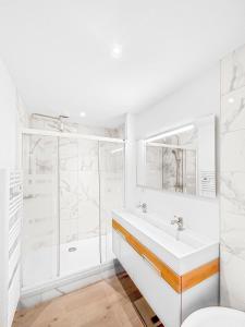 een witte badkamer met een wastafel en een douche bij Orléans hypercentre 4 pers appart avec cachet in Orléans