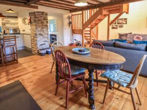 a kitchen and living room with a wooden table and chairs at Jane's Cottage in Ambleside