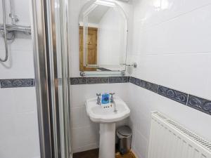 a white bathroom with a sink and a mirror at Tithe Cottage in Cockermouth +23 photos