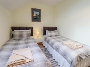 two beds sitting next to each other in a room at Tithe Cottage in Cockermouth