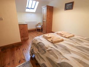 een slaapkamer met een bed met twee handdoeken erop bij The Byre in Cockermouth