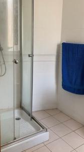 uma casa de banho com um chuveiro e uma toalha azul em Double bedroom with ensuite in spacious corner apartment em Birkirkara