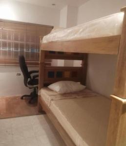 Zimmer mit 2 Etagenbetten und einem Schreibtisch in der Unterkunft Casa prado alto in Barranquilla