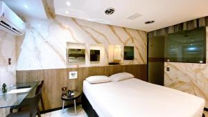 Motel Ceki Sabe في ناتال: غرفة نوم بسرير ابيض ومغسلة