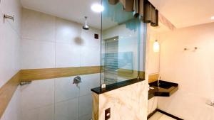 a shower with a glass door in a bathroom at Motel Ceki Sabe in Natal