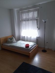 a bedroom with a bed with a window and a lamp at *Monteurwohnung* Hagen Bahnhof in Hagen