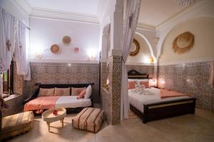 um quarto com duas camas e um sofá em Riad Arabesque em Marraquexe