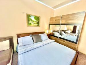 a bedroom with a large bed and a mirror at Apartment Centar in Podgorica