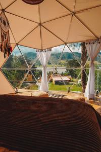 uma vista para um quarto com uma grande janela em Alma de Campo Glamping - Laguna de Suesca em Suesca