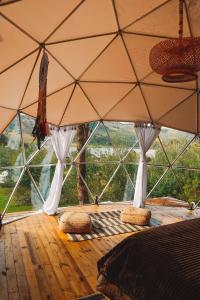 Camera con ampia tenda con cuscini su pavimento in legno. di Alma de Campo Glamping - Laguna de Suesca a Suesca