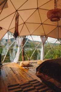 a room with a large window with a bed and pillows at Alma de Campo Glamping - Laguna de Suesca in Suesca