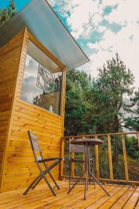 une cabine avec une chaise sur le pont dans l'établissement Alma de Campo Glamping - Laguna de Suesca, à Suesca