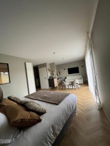 1 dormitorio con 1 cama y sala de estar en Le Clos des Huy Prés, en Trigny