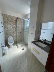 y baño con ducha, aseo y lavamanos. en Hostal Alvasar en Copacabana