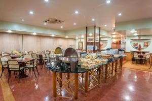 a buffet in a restaurant with tables and chairs at Hotel Dan Inn Planalto São Paulo in Sao Paulo