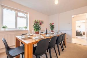 uma grande sala de jantar com uma mesa longa e cadeiras em Family water sports and cycling getaway - The Lake House em Ipswich