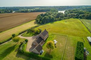 an aerial view of a house in a field at Family water sports and cycling getaway - The Lake House in Ipswich