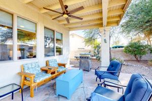 a porch with chairs and a grill with a ceiling fan at Sundial Serenity in Oro Valley