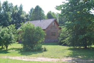 a house in the middle of a yard with trees at Rozītes in Cesvaine +8 photos