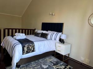 a bedroom with a large bed with white sheets and pillows at Luxurious Loft Condo in Fourways - A Hotel Experience with a Personal Touch in Sandton