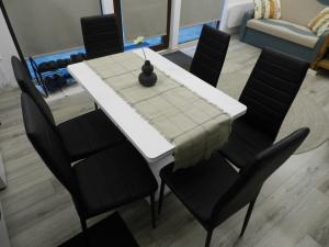 een eettafel met zwarte stoelen en een witte tafel bij ALI HOUSE in Poiana Fagului