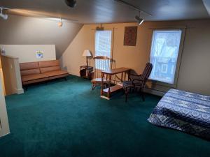 Kingfield的住宿－Terrapin Hostel，一间卧室配有一张床、一张沙发和一张桌子