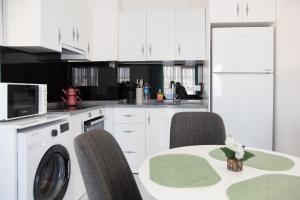 una cocina con armarios blancos y una mesa con sillas. en Art Life apartments (Olive), en Alanya